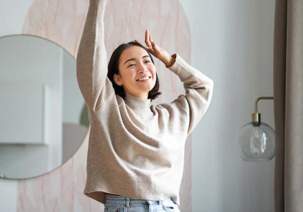 Young lady stretching and smiling in lounge room