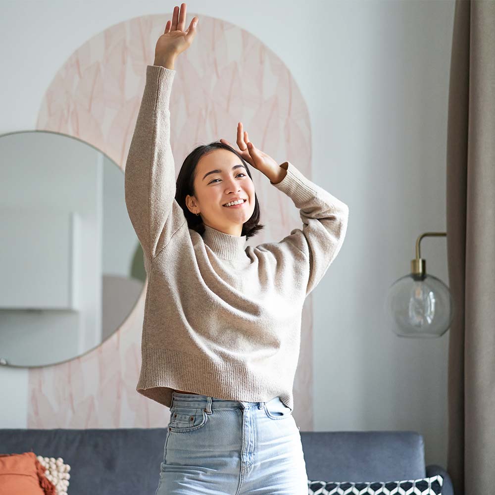 Young lady stretching and smiling in lounge room